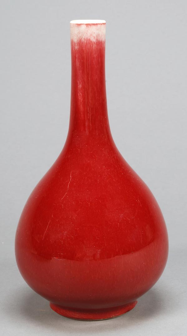 A Chinese sang-de-boeuf bottle vase, 18th century: A Chinese sang-de-boeuf bottle vase, 18th century, of cherry-red tone to a white glazed upper neck, 20.5cm high