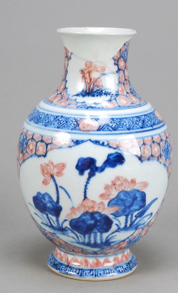 A Chinese underglaze blue and copper red ovoid vas: A Chinese underglaze blue and copper red ovoid vase, Qianlong, decorated with flowers and lotus, on a cellular ground, 19cm high