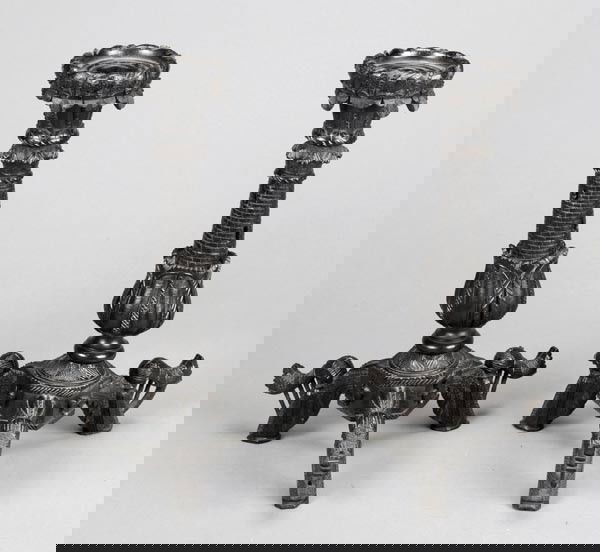 A pair of Irish carved and ebonised candlesticks,: A pair of Irish carved and ebonised candlesticks, late 19th century, each with shamrock carved circular rim, above a casselated and lotus carved stem on three downswept legs modelled as harps