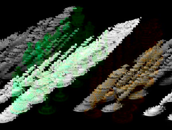 An Anglo-Indian Vizagapatam turned and carved ivor: An Anglo-Indian Vizagapatam turned and carved ivory chess set, circa 1870, stained green and natural, the pieces multi crocketed and foliate carved overall, the kings 11.5cm high, the pawns 6