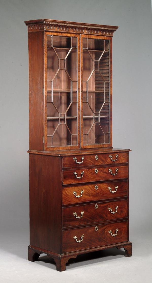 A George III mahogany bookcase on secretaire chest: A George III mahogany bookcase on secretaire chest, circa 1770, in the manner of Thomas Chippendale, the moulded cornice above a pair of astragal glazed doors, the fall-front secretaire openi