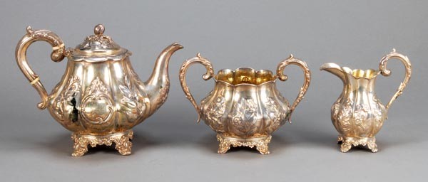 A matched Victorian silver three piece tea service: A matched Victorian silver three piece tea service by Richard Pierce & George Burrows, London 1847-50, lobed baluster, the tea pot with a melon finial, a domed cover, a foliate-capped S-scrol