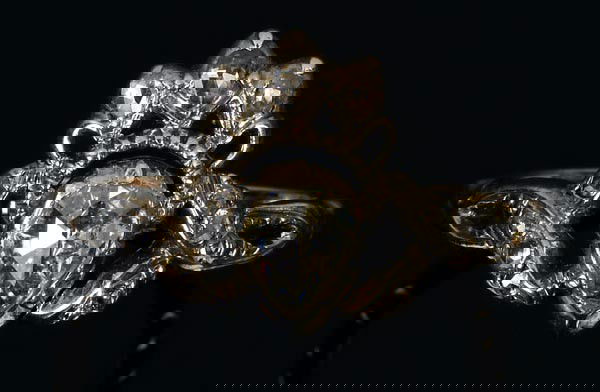 A Georgian diamond ring, circa 1780, the central p: A Georgian diamond ring, circa 1780, the central pear shaped rose cut diamond claw set in a closed backed gold backed silver cut down collet in a rose cut diamond bow mount, on a chased gold