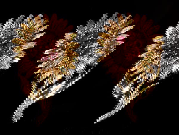 A pair of 1950s ruby and diamond ear clips by Bouc: A pair of 1950s ruby and diamond ear clips by Boucheron London, the flower head cluster tops centrally set with circular cut rubies within a square cut diamond border to old cut diamond stems