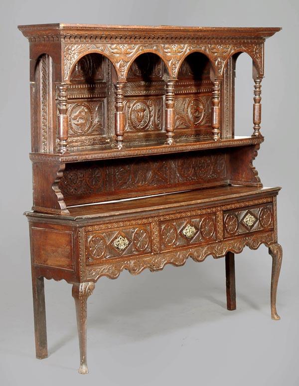 A George III oak dresser, circa 1760, possibly Iri: A George III oak dresser, circa 1760, possibly Irish, moulded rectangular top, three drawers and shaped apron, carved throughout with rosettes, guilloche, repeated leaves, cabriole legs and p