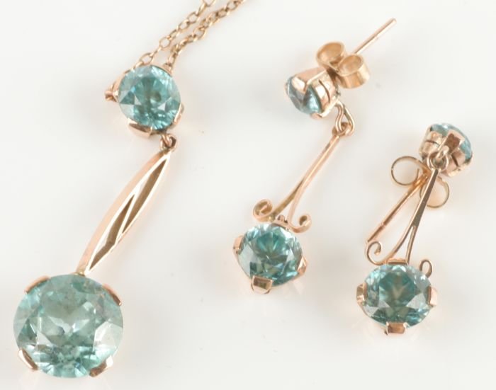 A blue zircon drop pendant on a chain, the round c: A blue zircon drop pendant on a chain, the round cut stone, of approximately 11mm diameter, to an open suspension with a smaller round cut above, of approximately 6mm diameter, on a chain 36c
