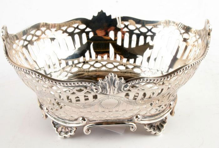 A late Victorian silver oval sweet basket by Charl: A late Victorian silver oval sweet basket by Charles Stuart Harris, London 1895, with a beaded and foliate shaped rim, pierced and engraved with drapery swags and patera, the foot rim with sc