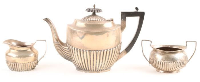 A matched three piece silver tea service, teapot W: A matched three piece silver tea service, teapot Walker & Hall, Sheffield 1912, cream jug and suger basin, by Charles Stuart Harris, London 1886, of oval gadrooned form, 854g (27.4 oz) gross<