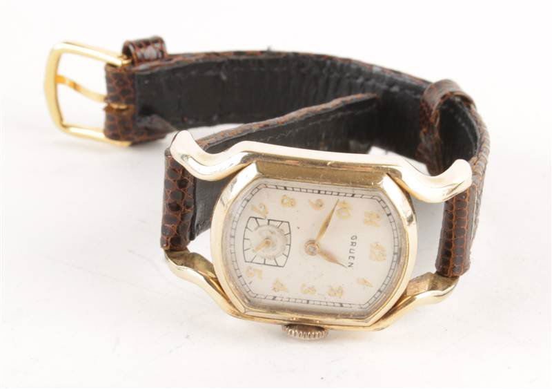 Gruen, Rristside Curvex Fraternity, a 1950s gentle: Gruen, Rristside Curvex Fraternity, a 1950s gentleman's gilt metal driver's watch, the two piece case with silvered dial with applied gilt Arabic numerals and feuille hands, and subsidiary se