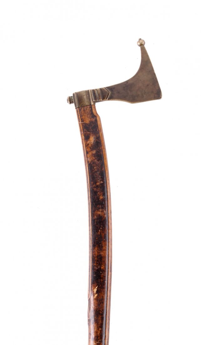 A Saxon Miner's Guild Axe, Late 17th / Early 18th: A Saxon Miner's Guild Axe, Late 17th / Early 18th Century, with flat brass head of characteristic form, on a slightly curved fruitwood haft, brass mounted with a shaped iron terminal, 107cm long.
