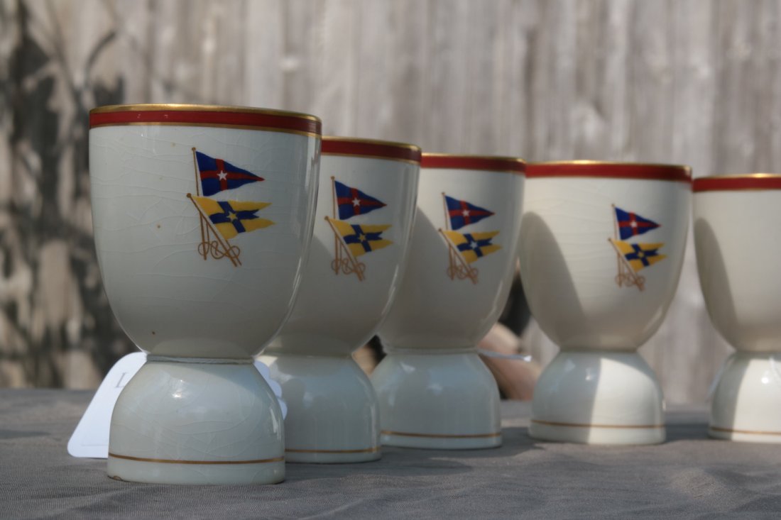 Group of Six Porcelain Egg Cups | New York Yacht Club,: Group of six (five pictured) porcelain egg cups decorated with burgee of the New York Yacht Club and private signal flag of Ralph Beaver Strassburger, owners of the Norristown Herald and owner of the
