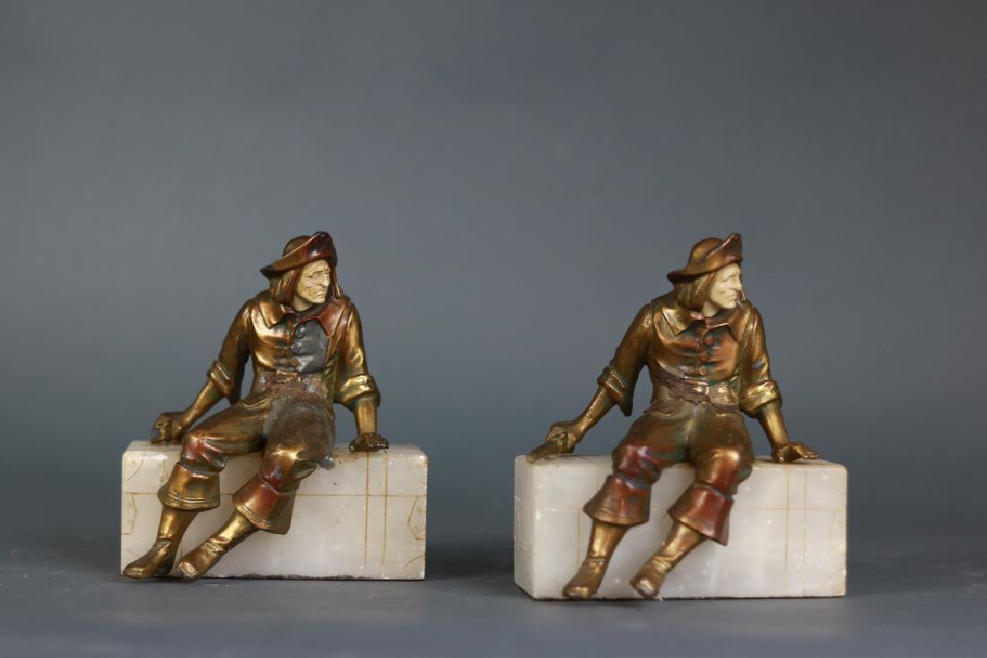 Bronze and Alabaster Bookends: Pair of bronze and alabaster bookends with seated pirates. One has a pistol in hand. The other pistol is damaged.