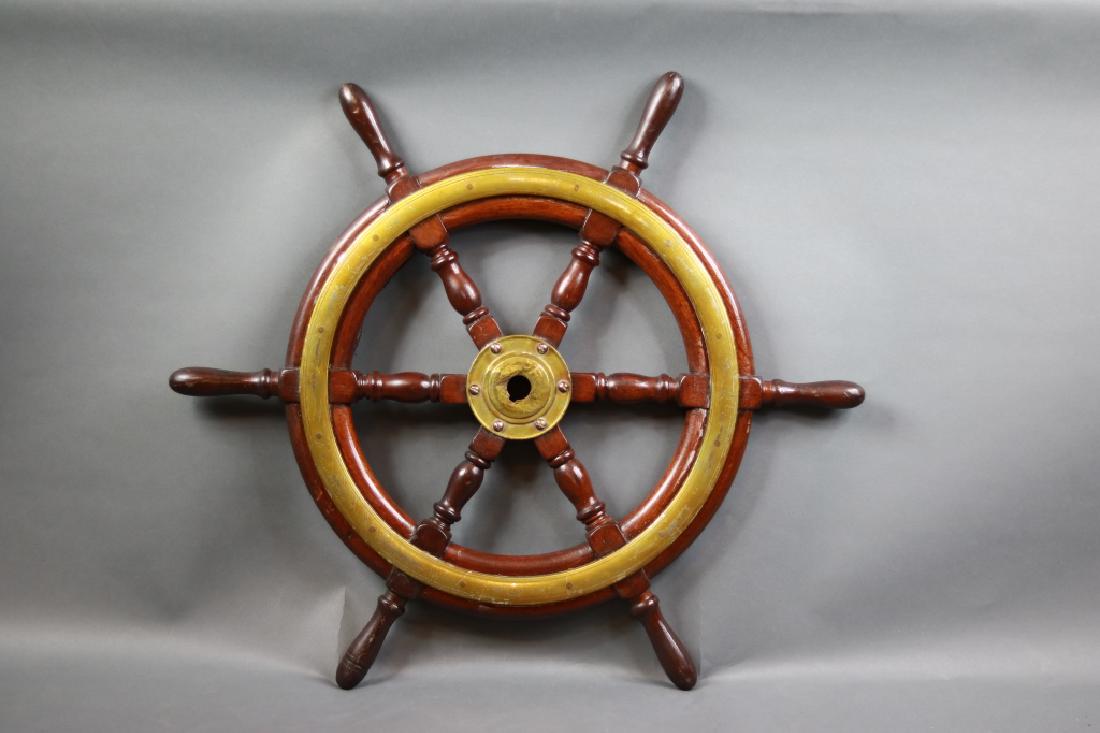 Mahogany & Brass Yacht Wheel: Varnished ship wheel with wide brass trim rings and heavy brass hub. 29 inch diameter.
