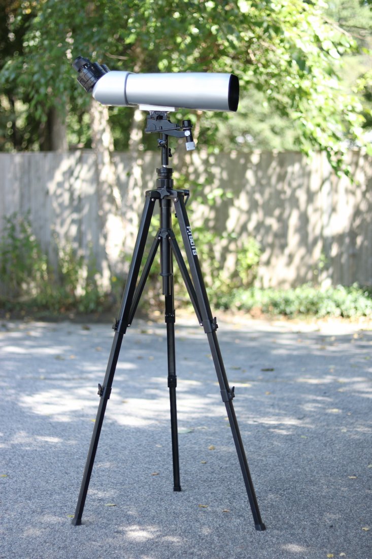 Pair of Precision Big Eye Binoculars: Big eye binoculars in silver painted case with cut Russian lenses. 25 x 100 and 25 x 40 adjustable eye pieces. Quite heavy. View is to the horizon. Set onto an aluminum tripod painted black.
