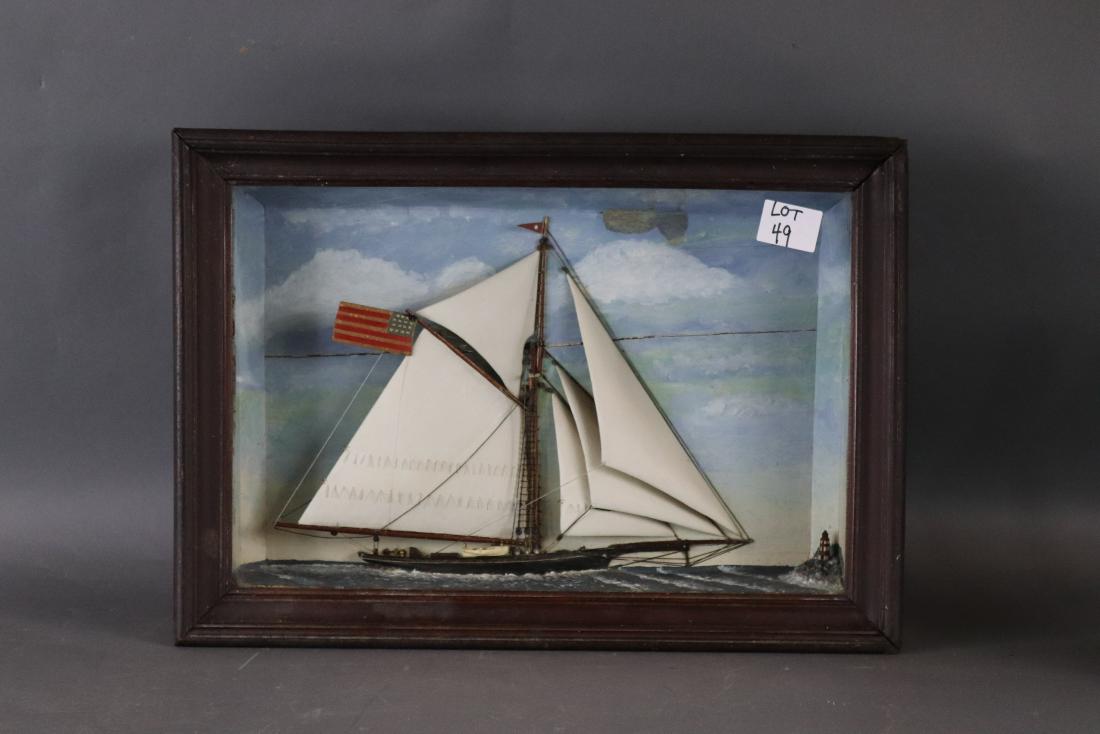 Charming shadow box of a yacht: Sailing sloop set at itâ€™s waterline into a diorama box with pleasant painted sky. A lighthouse is on a spit of land. Walnut frame. Well scaled. Wood sails, detailed deck. Interesting American f