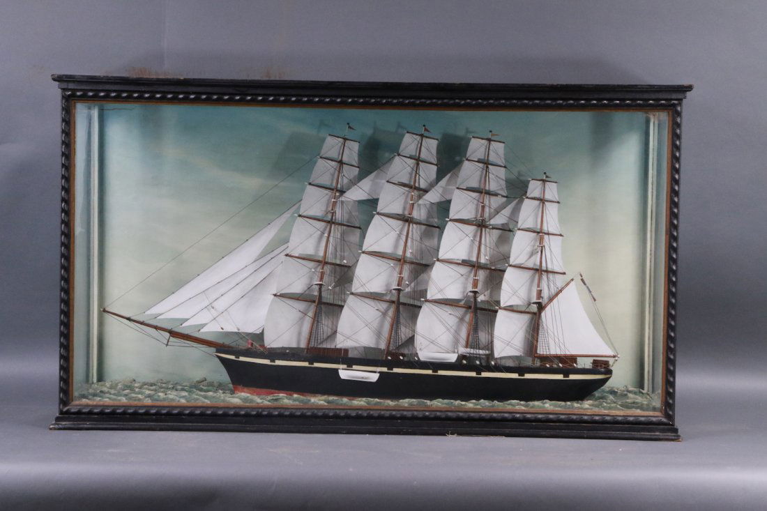Sleek shadow box of clipper goldfinger: Choice shadow box diorama showing the English clipper ship GOLDFINGER with four masts all carrying five carved sails. Varnished deck with cabins. Maiden figurehead. Lighthouse off the bow. 43 x 12 x