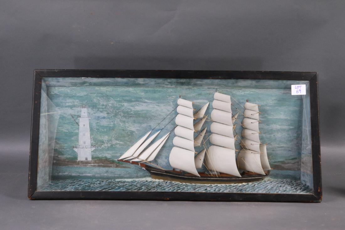 Antique clipper ship diorama: Nice early ship model of a clipper ship set at its waterline into a carved sea. A large lighthouse is painted on the background. 35 x 3 x 17