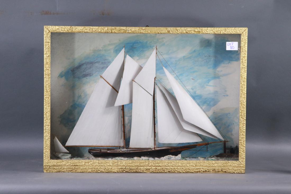 Antique Nautial Shadow box with Ship Model: Early 20th century shadow box diorama showing an American Schooner Yacht under full sail with varnished trailboard, long trunk cabin, painted wood sails, set into a gesso sea. Wood and gesso frame.