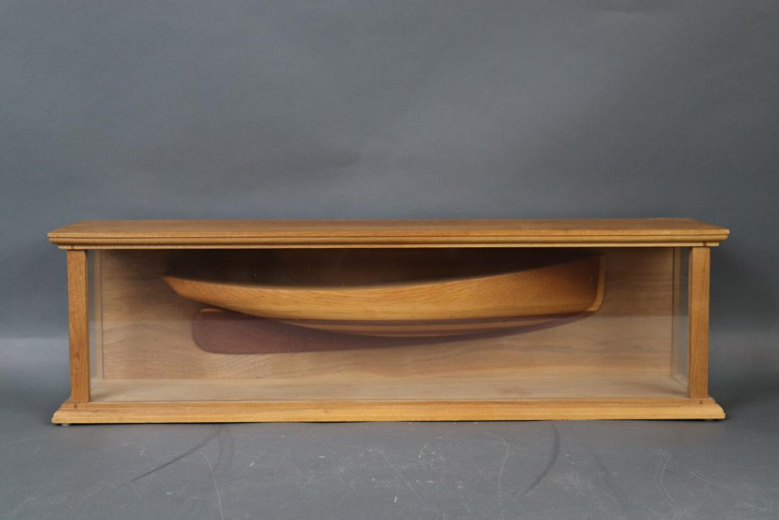 Carved half model in a shadow box: Finely carved half model of a catboat fitted to a custom case. 24 inches long x 6 inches wide x 7 inches tall.