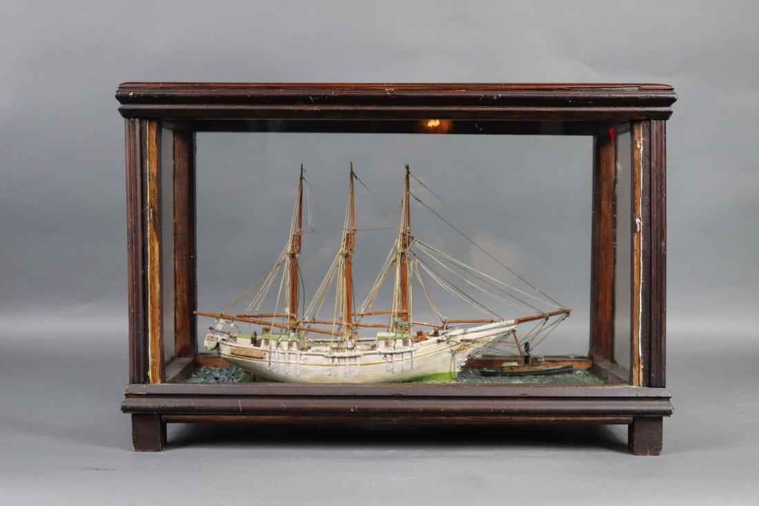 Cased folk art ship model: Cased model of the three masted coastal schooner MAE with tugboat in a gesso sea. 22 inches long x 10 wide x 14 high.