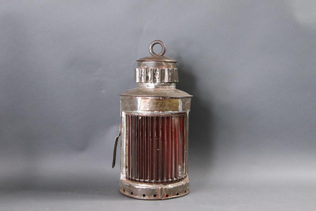 Nineteenth century ship port lantern: Portside ship lantern of steel withered ribbed lens by Russel and Watson of Buffalo, New York. With hinged door and vented top. Engraved brass tag. No burner. Late 19th century. 6 diameter x 12 tall.