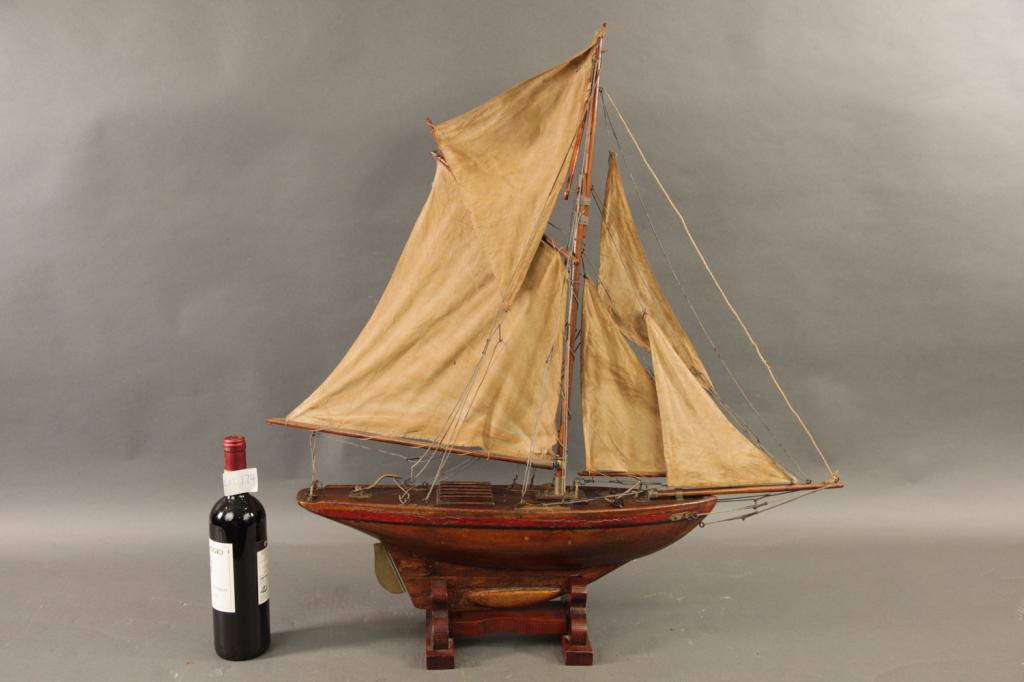 VINTAGE ENGLISH POND YACHT WITH SAILS: Vintage English sailing pond boat with a suit of five sails. Fitted with a lead keel. Set on a wood cradle. 34H X 30L X 6W