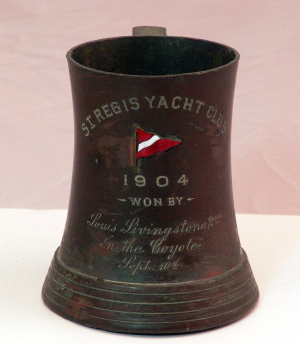 1904 St. Regis Yacht Club Trophy: 1904 Yachting Trophy - St. Regis Yacht Club. Inscribed trophy cup with closing yacht club burgee. Engraving reads "Won by Louis Livingstone, 2nd in the "Coyote", September 10th". Makers badge on botto