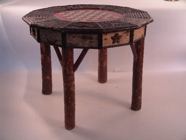 Adirondack style game table: Twelve-sided geometrical game table with checker/chess board center and Adirondack and birch wood style casing. 39 1/2" top diameter x 30 1/2" high.