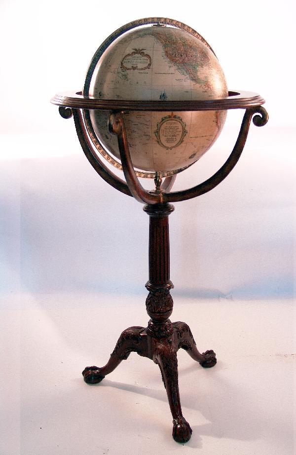 World Globe: World globe by Replogle on carved wood stand with reeded legs and ball and claw feet. Brass meridian ring, pedestal and other brass accents. 38 1/2" high x 16" sphere.