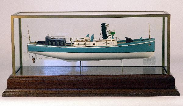 Cased model of an English Naval Pinnace.: Well detailed model of a British Admiralty steam launch. Model has many brass fittings including whistle, steam funnel, ventilator cowls, helm on pedestal, telegraph, searchlight, etc.. .Mounted to a 