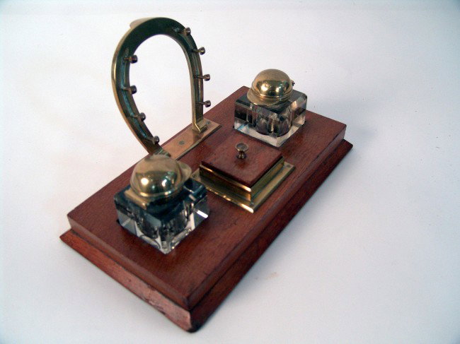 Desk set from steam yacht "Aloha". : Fine desk set from steam yacht "Aloha" with equestrian theme, showing pen holder set in the shape of a brass horseshoe, two inkwells - the caps of which are in the shape of jockey's hats with ink blot