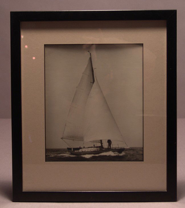 Yacht Photo by Norman Fortier: Black and white photo by marine photographer Norman Fortier showing a small sloop under full sail in calm seas. With photographers stamp. Matted and framed. On sight 9" x 7 1/2". Overall 14 1/2" x 12