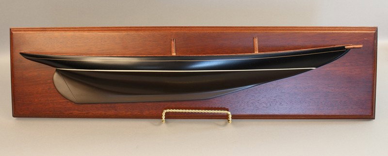 Carved half model of schooner "Bluenose".: Quality half model of the Canadian fishing schooner Bluenose. Hull is painted black above the waterline and bronze below with a white waterline and gold boot top. Deck is planked and fitted with two s