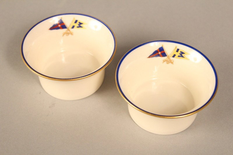 Two porcelain ramekins from a New York Yacht Club: Two porcelain ramekins by Lenox from the yacht Hi-Esmaro, owned by Hiram E. Manville. The ramekins have the New York Yacht Club Burgee crossing staff with the private signal flag of Manville's yacht. 