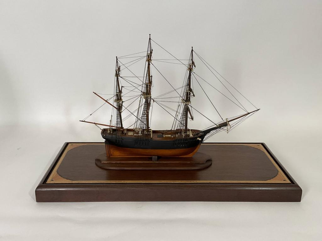 Nineteenth Century Ship Model in Case: Small antique clipper ship model in a case. The model has extensive bone trim including bowsprit, catheads, pin rails, winch, wheel stand, hatch, etc. Fitted to a custom inlaid case. Dimension: 15" H 