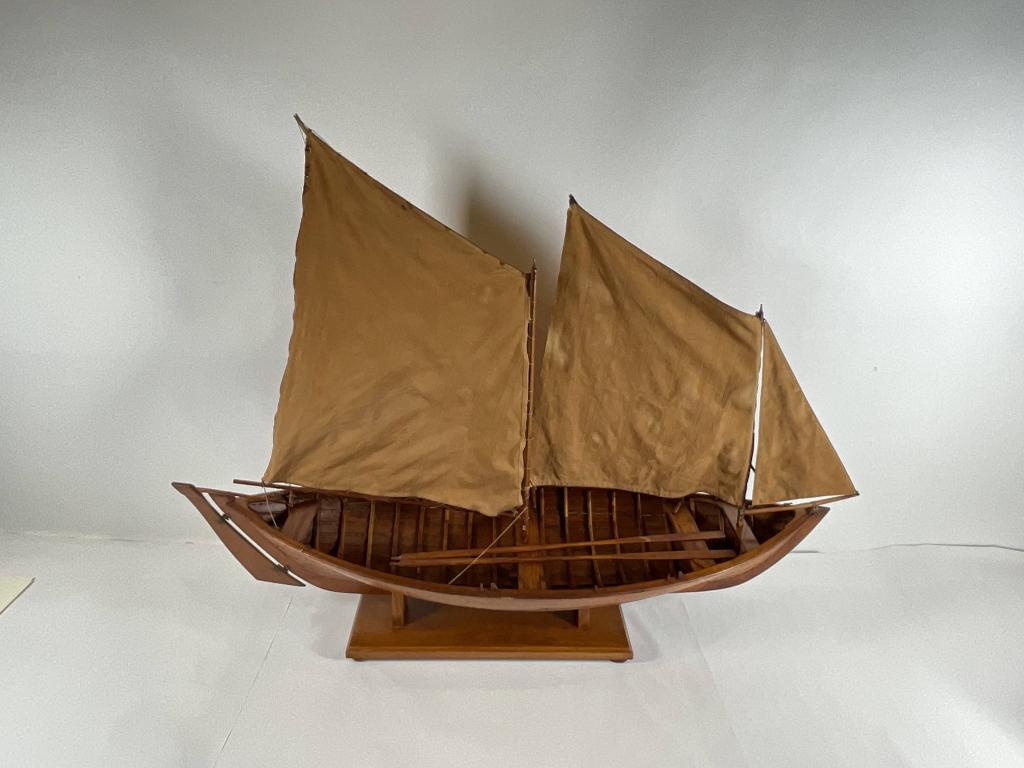 Antique Model of A Double Ended Watercraft: Early twentieth century model of A double ended watercraft. The hull is built of ribs, planks, benches, etc. warm patina finish. Rigged with a suit of dark linen sails. Old patches to sails. Quality a