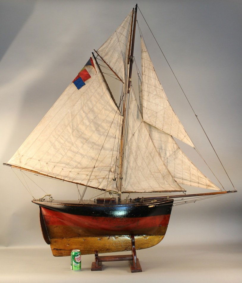 Vintage pond yacht of a cutter: Well preserved Edwardian pond yacht rigged with a full suit of linen sails, carved hull with lead keel, dark varnished and scribed deck that is outfitted with many brass fittings. 62" x 12" x 70".