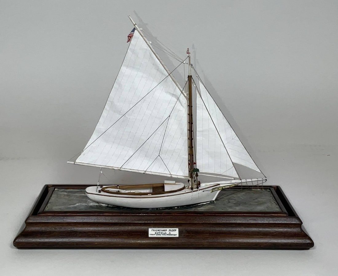 Colin Gray of Nantucket Boat Model: Small cased model of the friendship sloop "Estella A" by cherished ship modeler Colin Gray of Nantucket. The crisply detailed model shows ribs, benches, tiller, trailboards, and a full suit of sails.