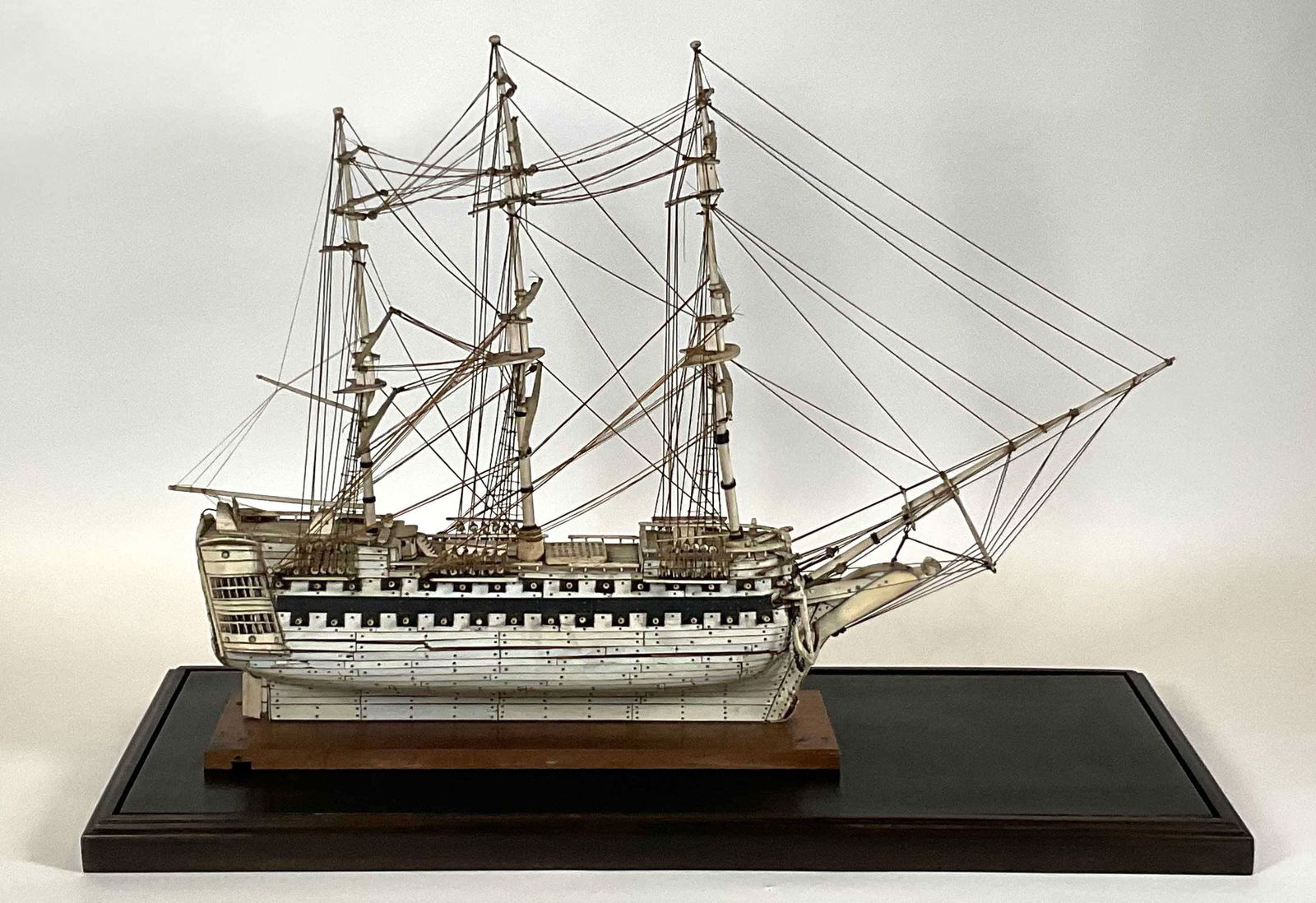 French Prisoner of War Bone Model: French Prisoner of War Ship Model with planked and pinned hull, carved woman mermaid figurehead, hatches, stairway, wheel, etc. Hull has fifty eight cannon protruding from the hull. Fully rigged with