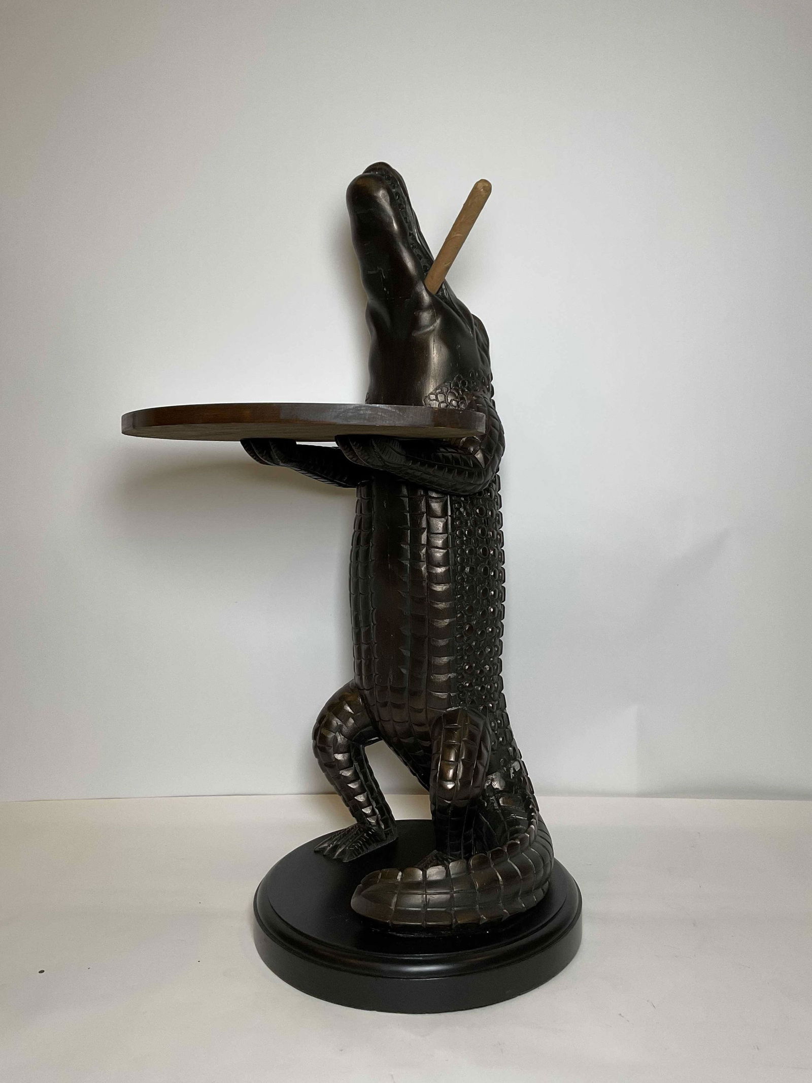 Carved Wood Alligator Wine Table: Carved wood alligator with cigar in his mouth holding a wood tray. This charming accessory is perfect for a wine cellar or den. The carved alligator is in a standing position and is mounted to a thick