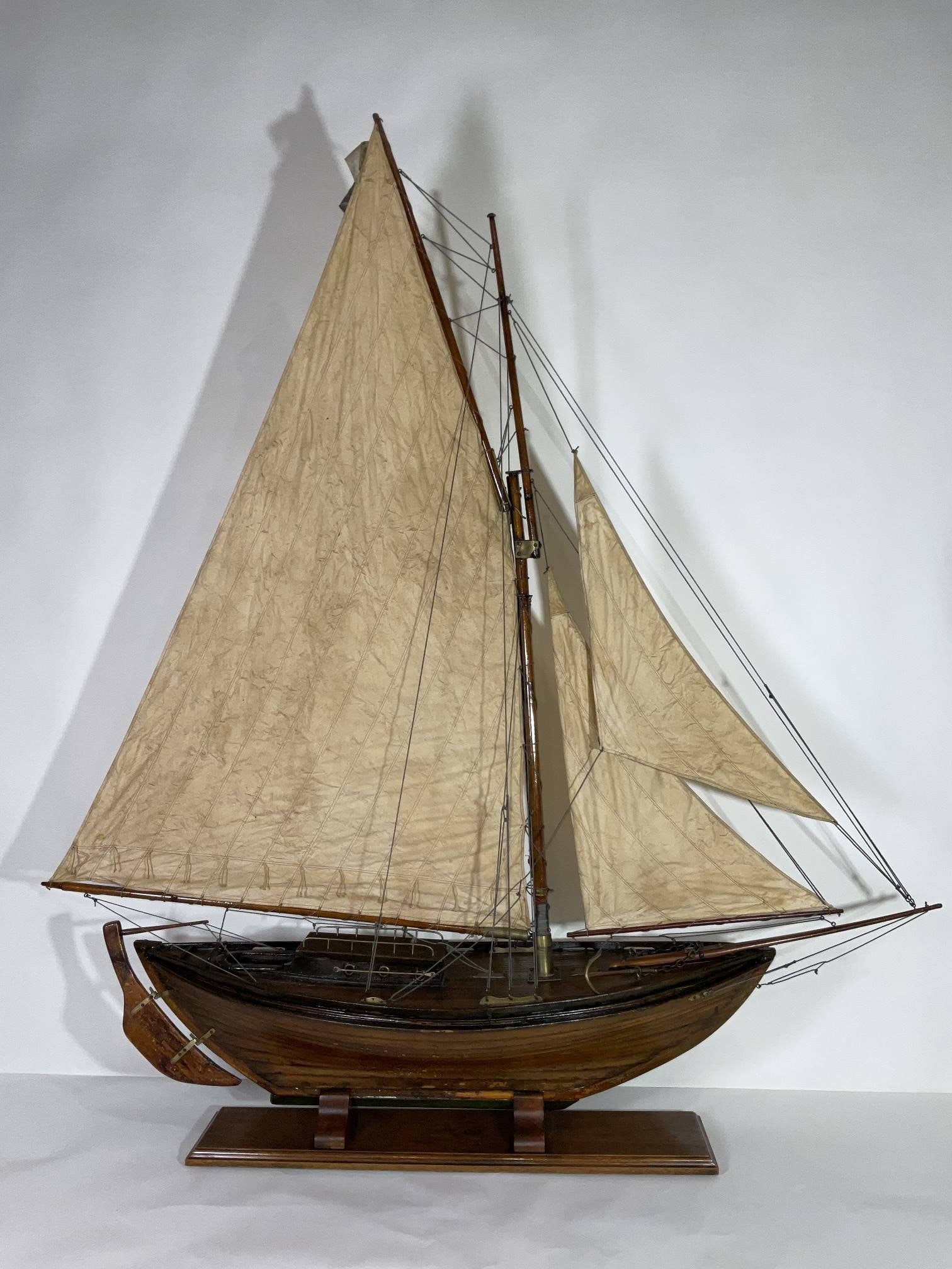 Antique Pond Model of a Double Ended Sloop: Five foot, early twentieth century model of a double ended sloop, rigged with a full suit of sails. Many brass fittings. The plank on frame hull has a nice varnish finish. Wood cradle very nicely buil