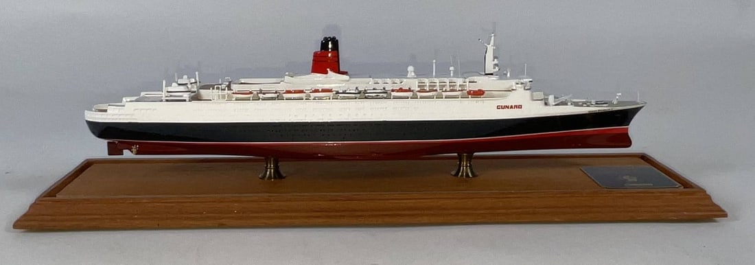 Queen Elizabeth II Ship Model in Case: Issued by Cunard years ago, this is a full hull promotional model of the revered Queen Elizabeth 2. This QE2 detailed replica is in a plexiglass case 3 3/4" wide x 4 1/2" high x 15" long. Built by Joh
