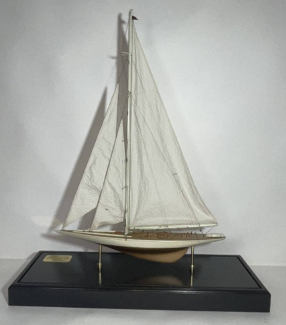America's Cup Yacht Rainbow in Case: Cased model of the 1934 America's Cup Yache Rainbow in glass display case. With a full suit of linen sails. Planked deck with brass winches, toe rails, skylights, companionway, wheel, binnacle, etc..