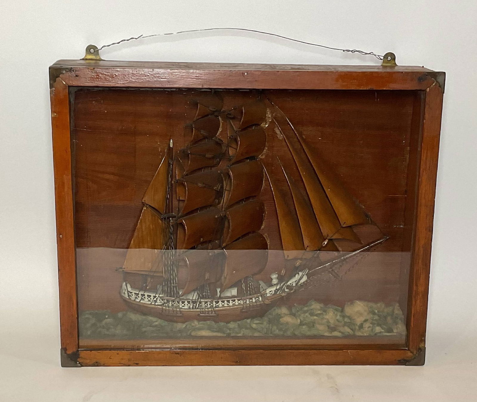 Antique Shadowbox Ship Model: Antique clipper ship model in a shdadow box frame. The vessel carries a suit of seventeen, carved wood sails with varnish. Charming hull form. Detailed railings. Set into a cotton sea. 18"Hx22"Wx5"Dee