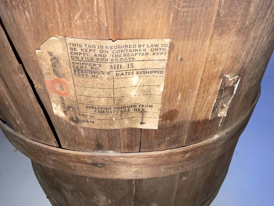 Chesapeake Bay Oyster Shipping Basket: Oyster basket with faint lettering that reads also has tag with "Shippers Certificate Number 15" and "Shellfish dredged from Chesapeake Bay". This oyster basket is well constructed with wood staves, s