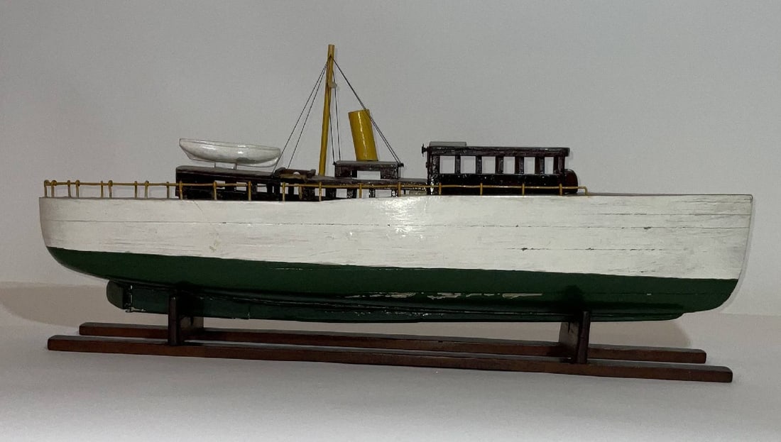 Steam Yacht Model on Wood Cradle: Charming boat model of a single funnel steam yacht with varnished cabins and wheelhouse. Painted hull. 7 lbs. 13"H x 28"W x 5"D.