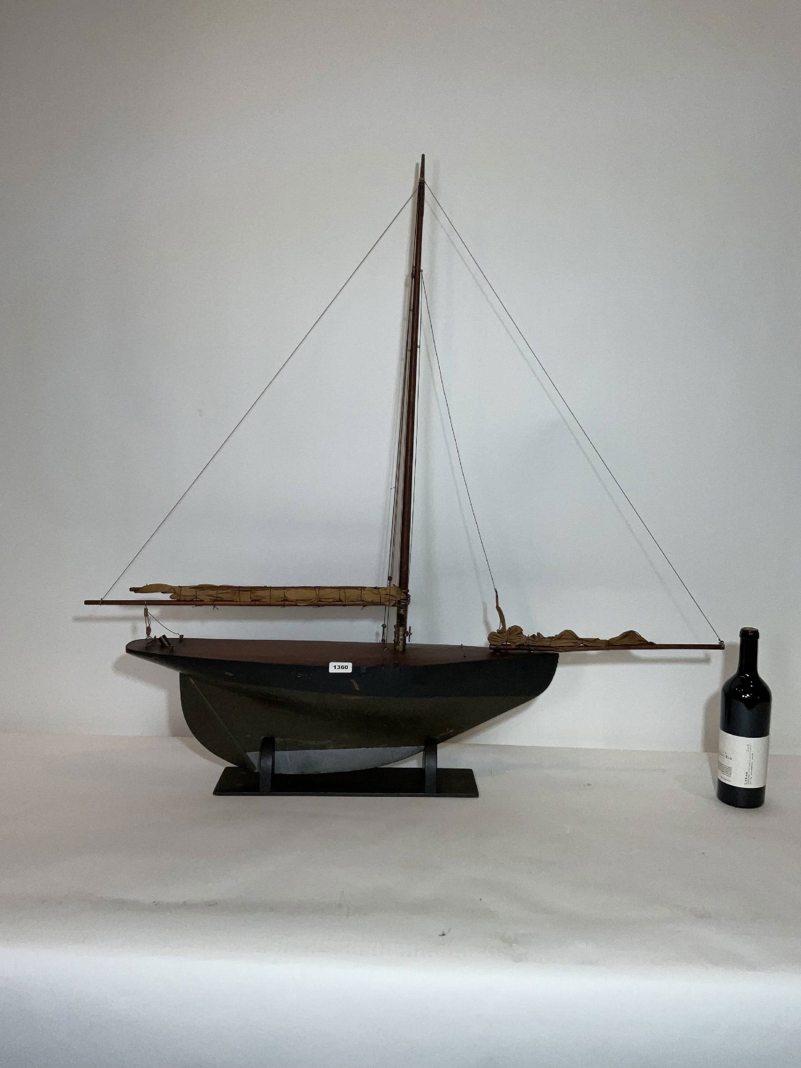 Vintage Pond Yacht that is 44 Inches Long: Antique pond boat with a lead keel, furled sails, cradle, and a good rig. The deck is scribed and varnished. 11 lbs. 43"H x 44"W x 7"D.