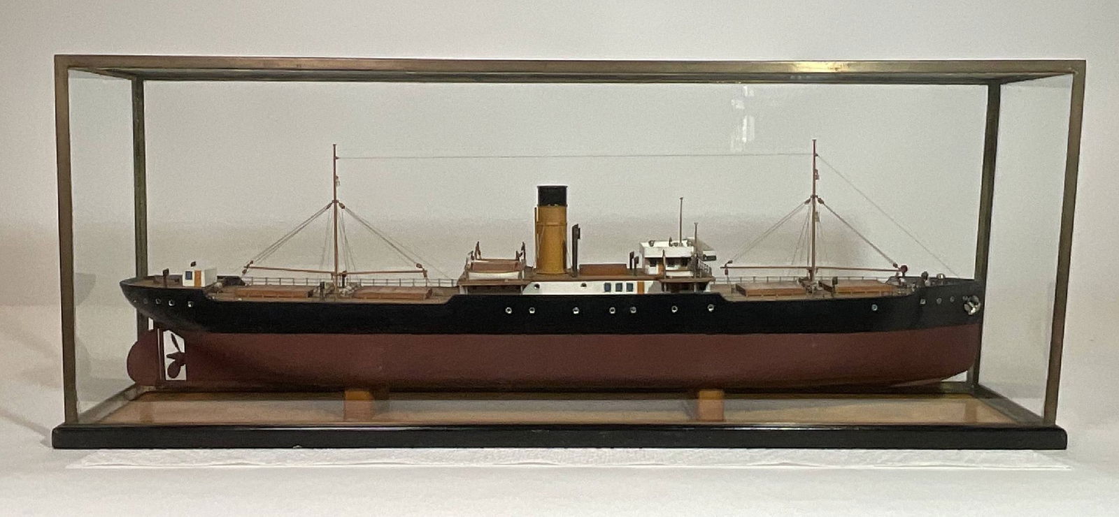 A Bassett-Lowke center island coastal freighter: This model has all the hallmarks of Bassett-Lowke craftsmanship, including beautiful natural wood deck markings, brass hardware and other techniques borrowed from their full "builders" models. It is p
