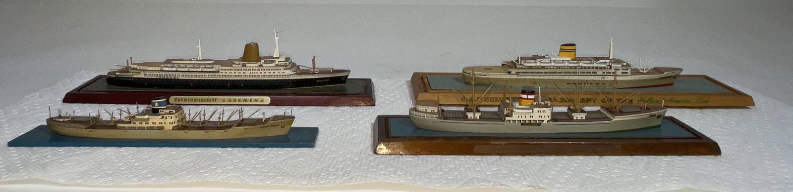 Grouping of four Richard Wagner "travel" scale models: Another grouping of four Richard Wagner "travel" scale models. This grouping does not have covers, and are mounted on miscellaneous bases. The ships are the Egda for the Cosmopolitan Line, Bremen (tur
