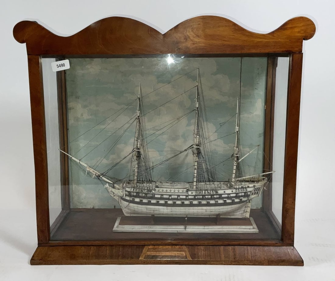 Prisoner of War Style Ship Model: Nineteenth century ship model of an English warship. The model is fully rigged without sails, including intricately executed standing and running cords. Hull is planked in bone. The deck has cannon on